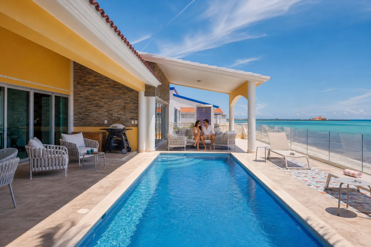 Couple on the Casa Karma pool terrace with the Caribbean and beach beyond